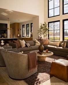 a living room filled with furniture and large windows