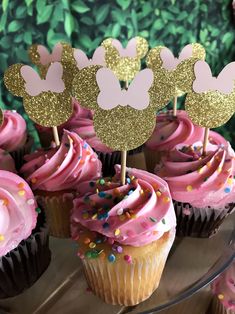 cupcakes with pink frosting and gold minnie mouse toppers