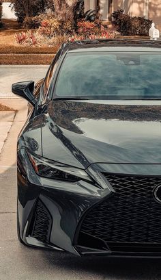 a black sports car parked on the side of the road in front of a house