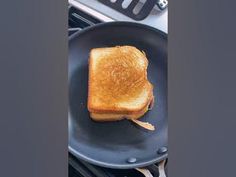 a grilled cheese sandwich is being cooked in a frying pan on the stove