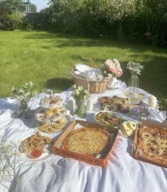 an outdoor picnic with pizza and other food