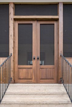 two wooden doors with metal handrails and windows