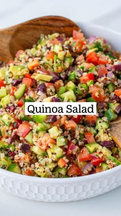 quinoa salad in a white bowl with a wooden spoon on the side that says quinoa salad