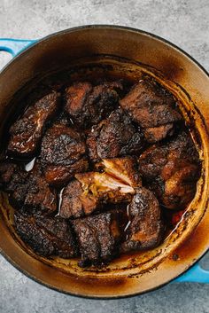 a pot filled with meat sitting on top of a table