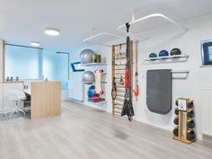 an office with white walls and hard wood flooring, sports equipment on the wall