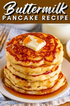 a stack of pancakes with butter and syrup on a white plate next to some fruit