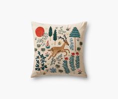 an embroidered pillow with deer and trees on it