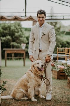 a man standing next to a golden retriever on top of a grass covered field