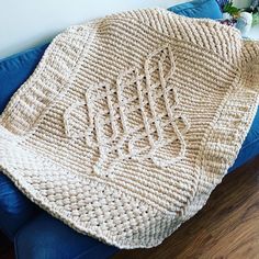 a crocheted blanket sitting on top of a blue couch