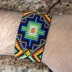 a man's arm with a colorful beaded bracelet on it