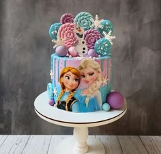 there is a cake decorated with frozen princesses on it