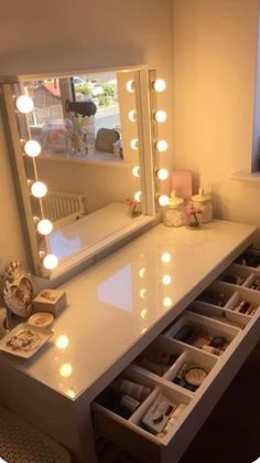 a vanity with drawers and lights on it