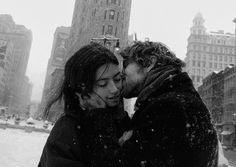 a man and woman kissing in the snow