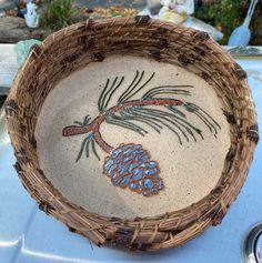 a basket with a pine cone painted on it