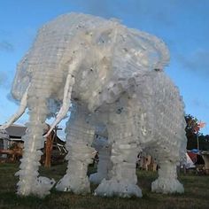 an elephant made out of plastic bottles in the grass