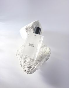 a bottle of cologne sitting on top of a rock