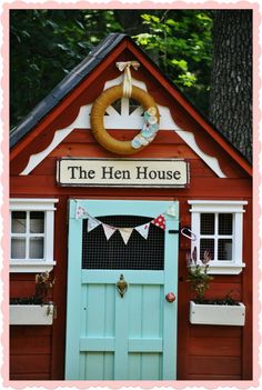 a red and blue house with a wreath on the front door that says the hen house