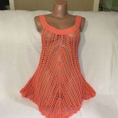 an orange crocheted tank top on a mannequin