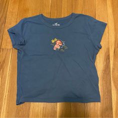 Hollister Blue Flower Embroidered Mini Baby Tee Short Sleeve Cropped T-Shirt Xs Nwot In Perfect Condition, Bought But Never Wore It So Cute But Not My Style Anymore Pm Or Comment With Questions/Offers #Hollister #Babytee #Embroidered #Flowers #Floral #Tshirt Light Blue Embroidered Tops With Crew Neck, Light Blue Short Sleeve Top With Floral Embroidery, Casual Blue Top With Embroidered Graphics, Casual Blue Tops With Embroidered Graphics, Blue Casual Top With Floral Embroidery, Blue Embroidered Crew Neck Top, Casual Blue Top With Floral Embroidery, Blue Crew Neck Top With Floral Embroidery, Blue Crew Neck Tops With Floral Embroidery