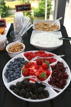 a table topped with plates and bowls filled with fruit next to other foods on top of it