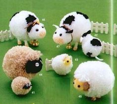 there are sheep and lambs standing in the grass near a fence with words written in japanese