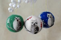 three ornaments hanging from a tree decorated with snowflakes and twine balls in the shape of owls