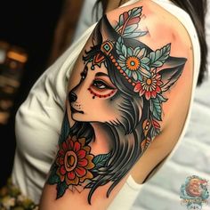 a woman's arm with a tattoo on it that has a wolf and flowers on it