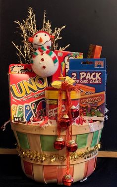 a christmas gift basket filled with candy, candies and a snowman decoration on top