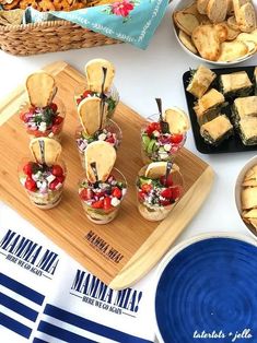 an assortment of appetizers are displayed on a table with plates and napkins