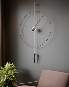 a clock mounted to the side of a wall next to a chair and potted plant