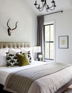 a bedroom with a large bed and a deer head mounted on the wall above it