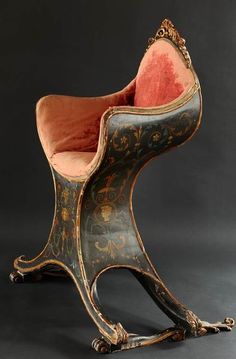 an antique chair with red velvet upholstered on the back and seat, sitting in front of a black background