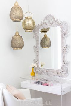 a white desk topped with a mirror and two hanging lights