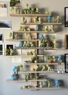 there are many shelves on the wall that have different items on them, and one shelf is filled with little green people