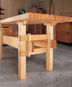 a wooden table sitting on top of a floor in front of a mirror with an advertisement for furniture