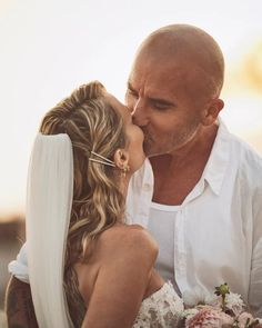 a man and woman kissing each other on their wedding day