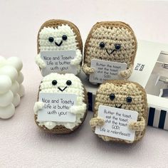 four crocheted toasted breads with funny faces and words written on them