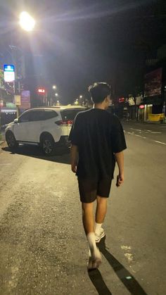 a man walking down the street at night