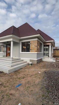 a house under construction in the middle of a dirt lot with steps leading up to it