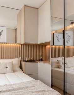 a white bed sitting next to a mirror on the wall in a room with wooden paneling