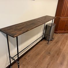 a long wooden table sitting on top of a hard wood floor