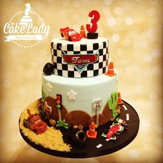 a three tier cake with cars and numbers on the top is decorated in fondant