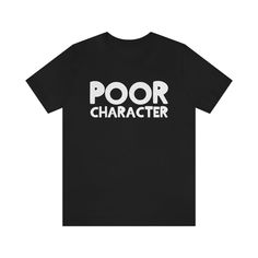 A classic black t-shirt that proudly displays the Poor Character logo. Get yours today! About our T-Shirts: Made with 100% Airlume combed and ringspun cotton, this unisex t-shirt is both soft and durable. With a retail fit and ribbed knit collars, it fits like a dream and holds its shape thanks to dual side seams. The lightweight fabric makes it perfect for any occasion, and with a tear away label, you can wear it your way. Choose from a range of colors to make it your own, and rest easy knowing Black Soft-washed Short Sleeve Shirt, Everyday Black T-shirt With Slogan, Relaxed Fit Black Soft-washed T-shirt, Black Relaxed Fit Soft-washed T-shirt, Black Soft-washed Relaxed Fit T-shirt, Basic Black Tops With Funny Text, Black Slogan Top For Everyday, Casual Black T-shirt With Comfortable Fit, Black Soft-washed Graphic Tee