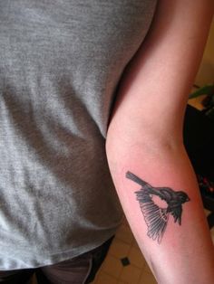 a person with a bird tattoo on their arm