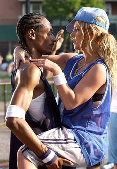 a man and woman dancing together in the street