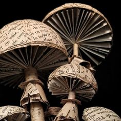 three paper umbrellas are stacked on top of each other with words written all over them