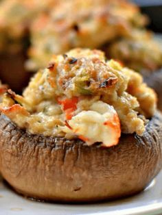 a close up of a stuffed mushroom on a plate with other food items in the background