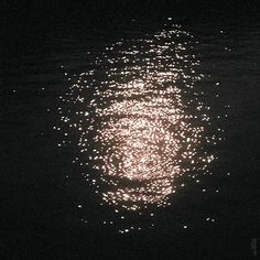 the light is shining on the surface of the water and reflecting off it's surface