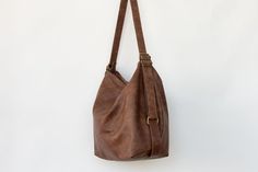 "Convertible leather bag: Converts from backpack to shoulder bag and crossbody bag with the single use of one strap. The main style of the bag is a soft and slouchy hobo bag. The permanent long strap on the bag can be easily adjusted to your desired length in order to wear the bag on your shoulder, as a crossbody bag or as a backpack. **Important point is that when you adjust the strap to a backpack the strap is stable and does not slide from one side to the other. Made from soft Italian distres Versatile Brown Hobo Bag With Detachable Strap, Everyday Shoulder Bag With Detachable Strap, Hobo Shape, Everyday Hobo Shoulder Bag With Detachable Strap, Brown Hobo Bag With Detachable Strap For Everyday, Versatile Everyday Crossbody Hobo Bag, Versatile Crossbody Hobo Bag For Everyday, Everyday Hobo Bucket Bag With Adjustable Strap, Versatile Hobo Bag With Detachable Strap For Errands, Versatile Hobo Shoulder Bag With Adjustable Strap