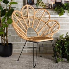 a wicker chair sitting in front of a brick wall next to a potted plant